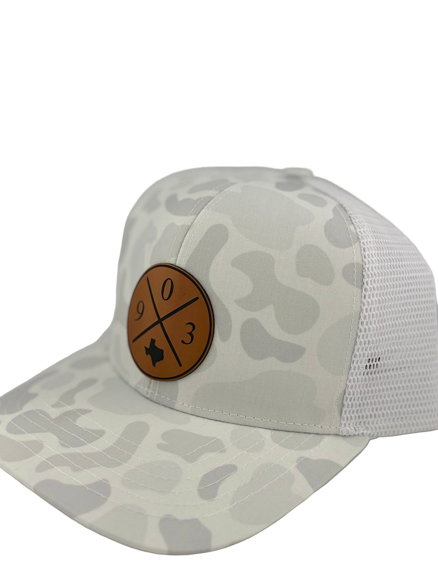 "Side view of a white and light gray camo-patterned trucker hat with a structured front and white mesh back. The brown leather patch on the front displays a crossed-line design with '9', '0' and '3,' along with a Texas state silhouette, adding a regional touch to the stylish headwear."