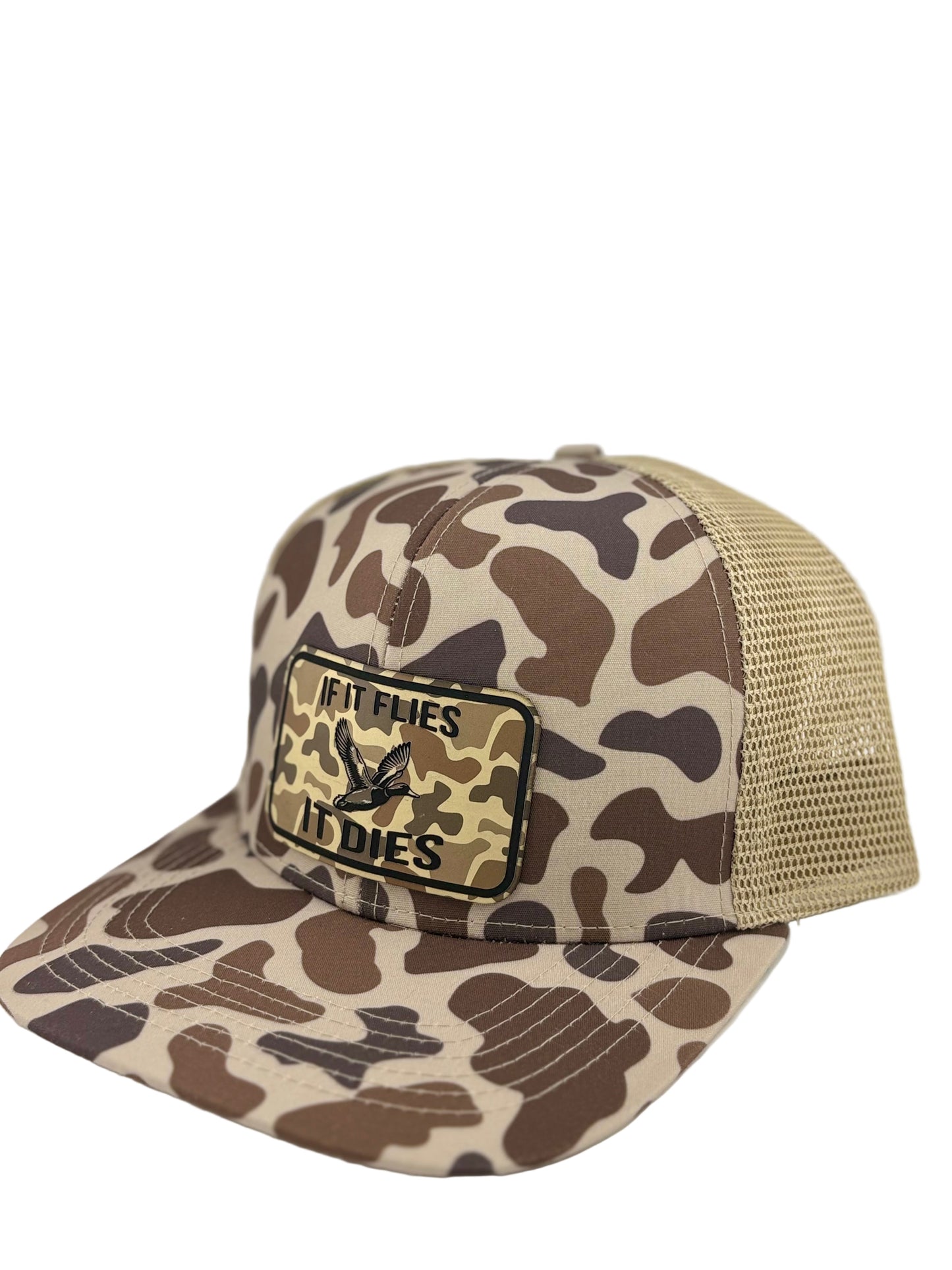 "Side view of a brown and tan camo-patterned trucker hat with a structured front and tan mesh back. The front patch, featuring a flying duck and the phrase 'IF IT FLIES IT DIES,' stands out against the camo backdrop, making it a bold statement piece for hunters and outdoor lovers."