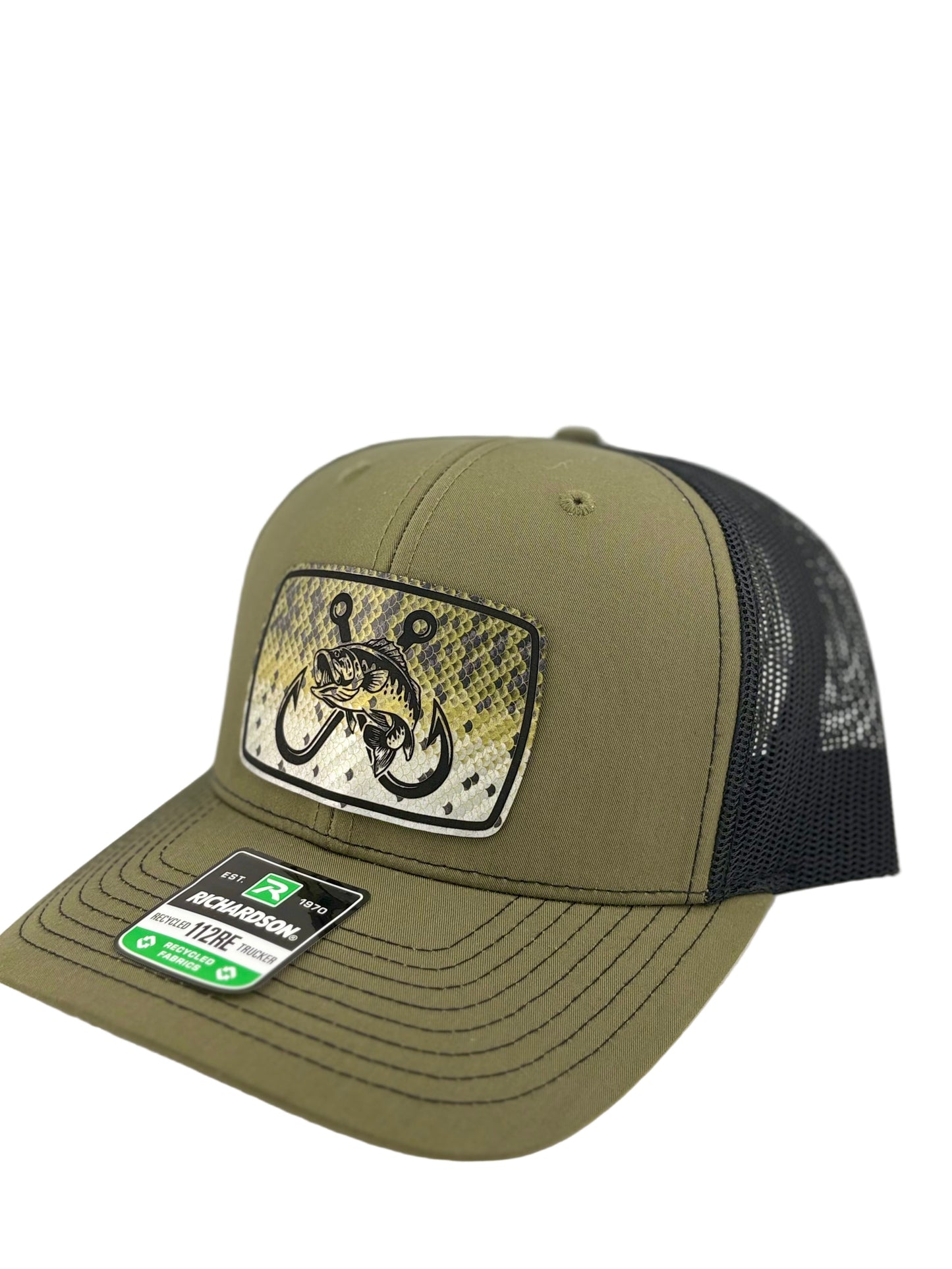"Side view of an olive green trucker hat with a black mesh back and a structured front panel. The front patch showcases a fish-scale background with a bold fish and double hook design, blending outdoor and fishing aesthetics. The hat's curved brim has visible stitching, and a Richardson 112RE label is placed on it."